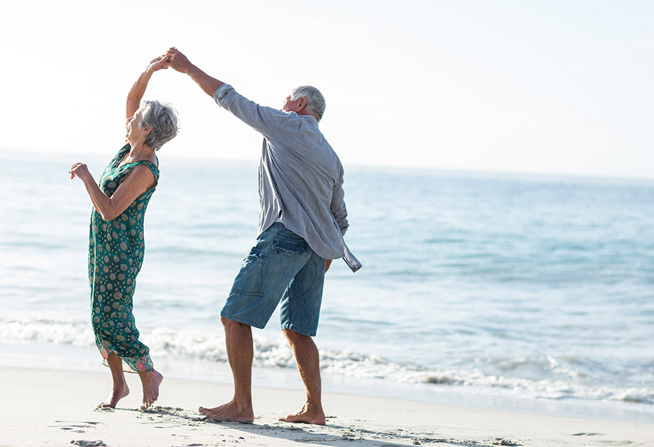 Caucasian couple dancing on the beach