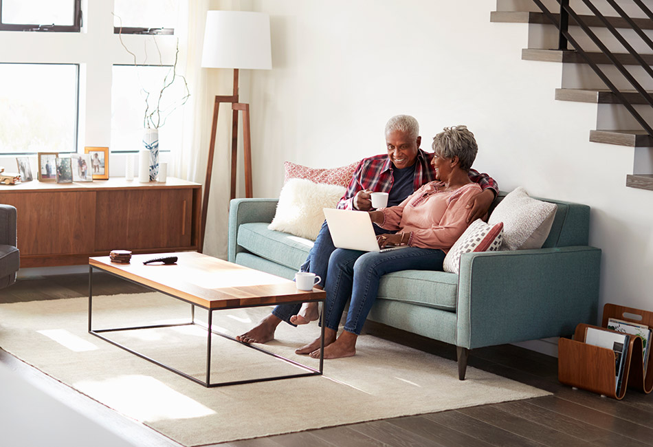 African American couple sitting with laptop and coffee