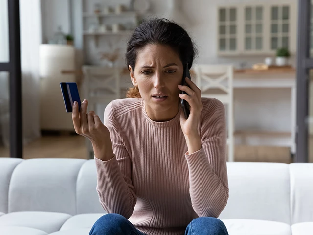 Concerned woman holding a credit card on the phone