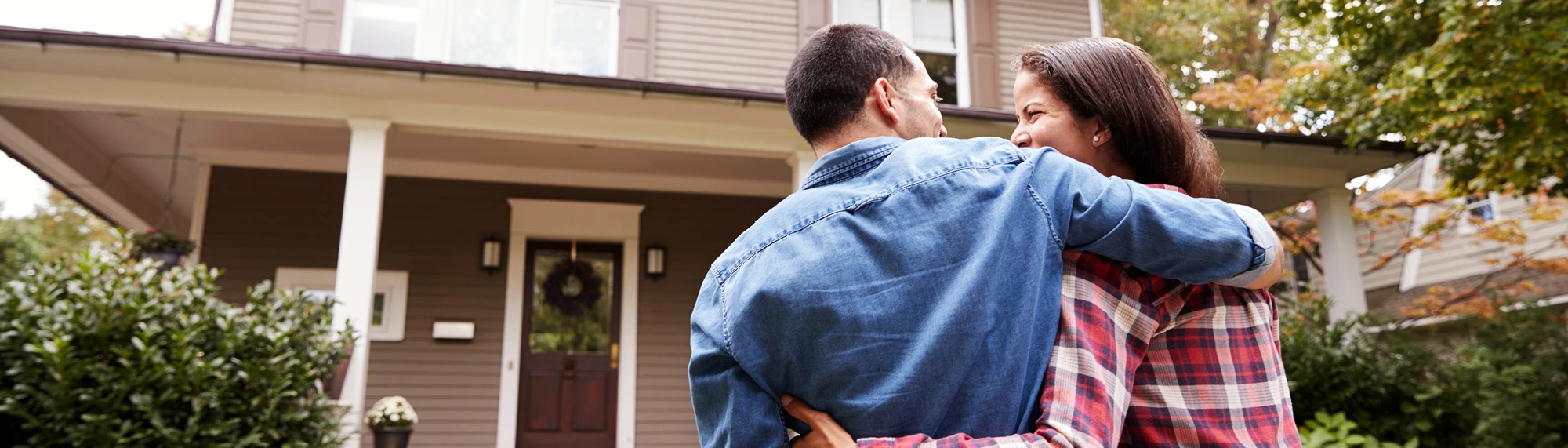 young couple in front of new home