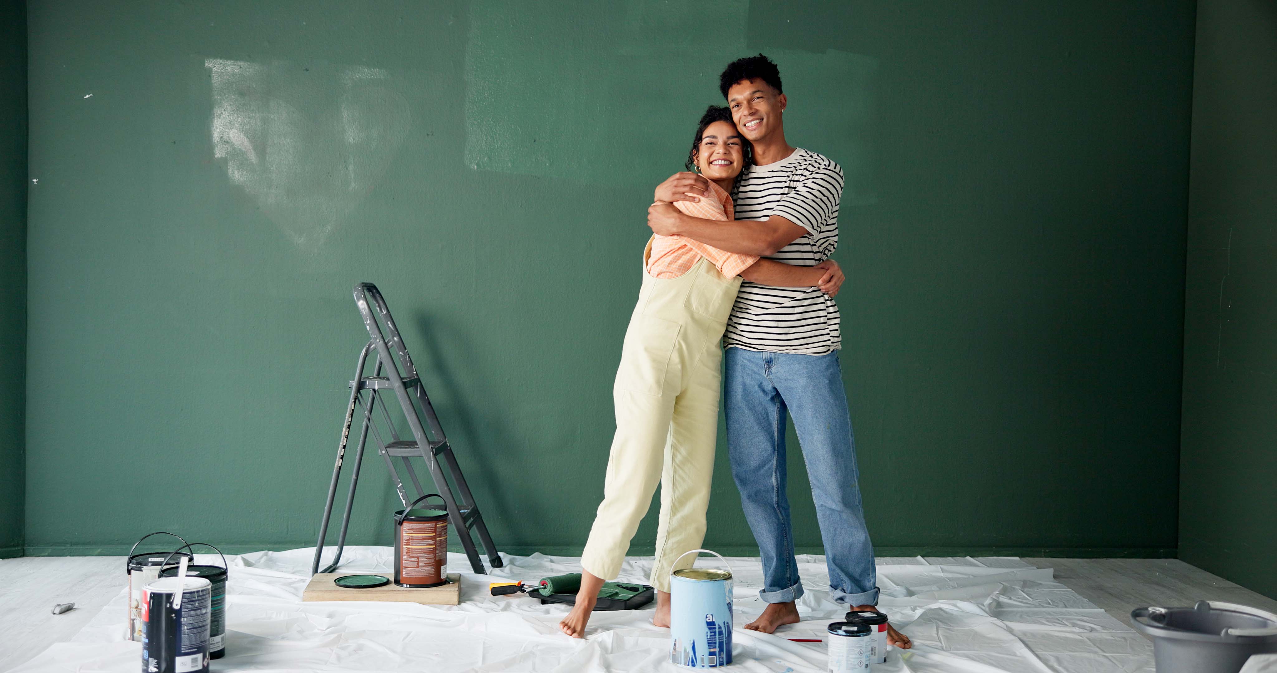 couple hugging in front of newly painted wall
