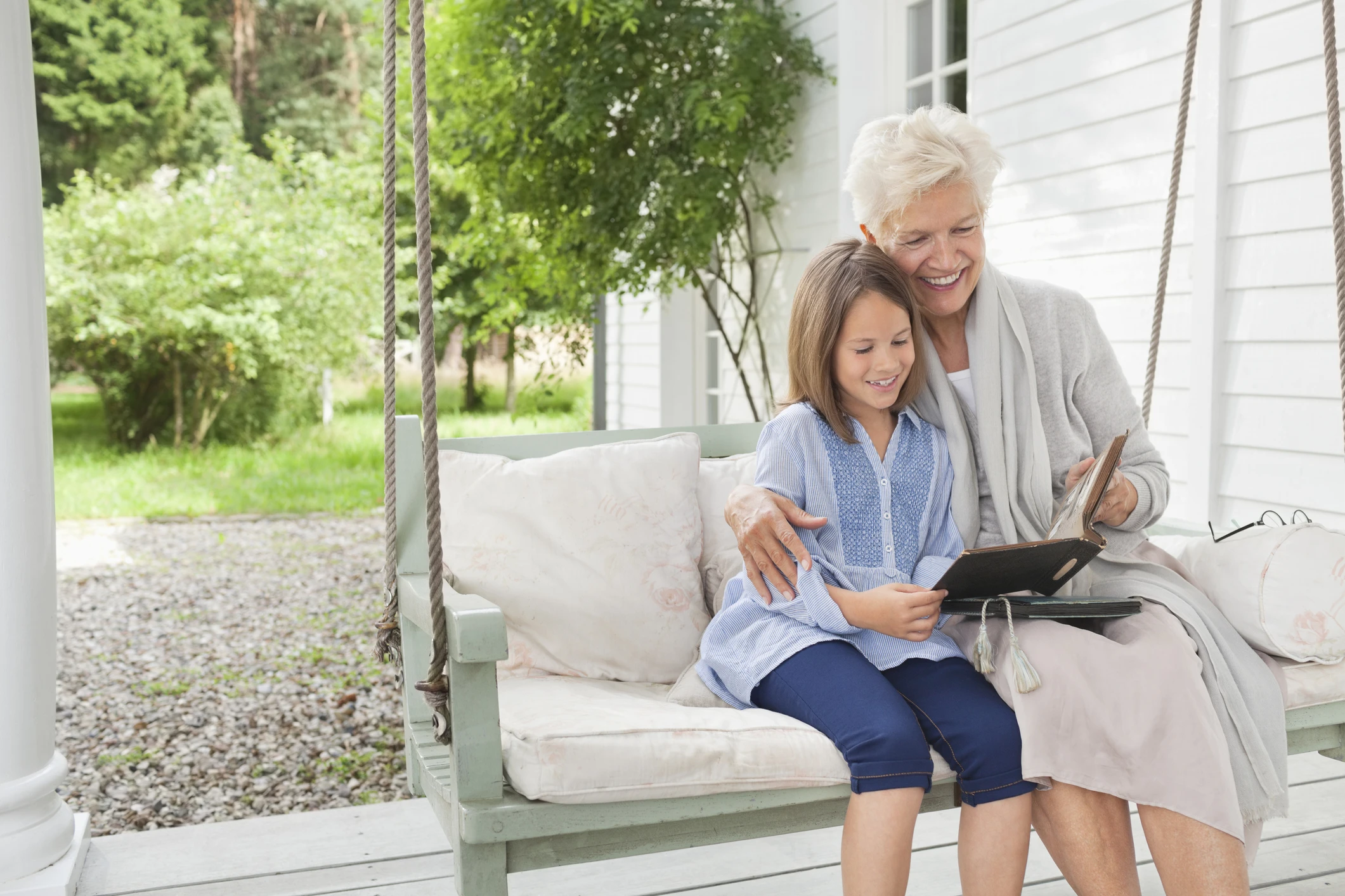 caucasian grandma and granddaughter on porch swing