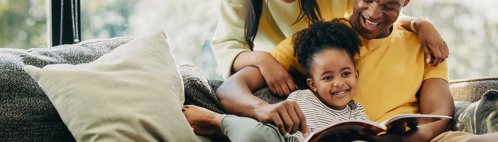 african american family reading on couch at home