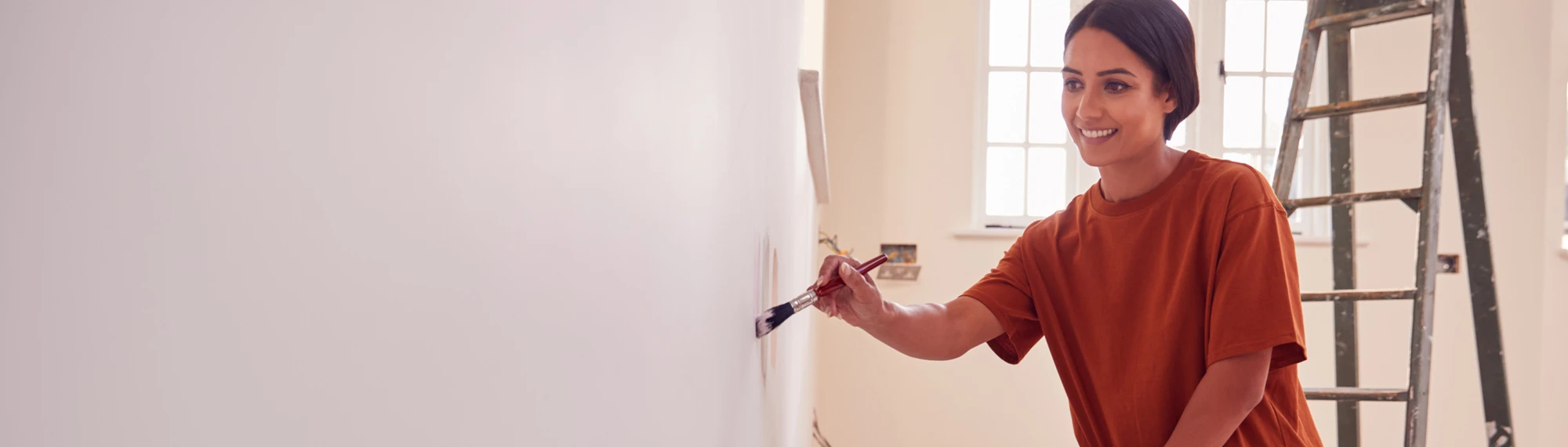 caucasian woman painting walls