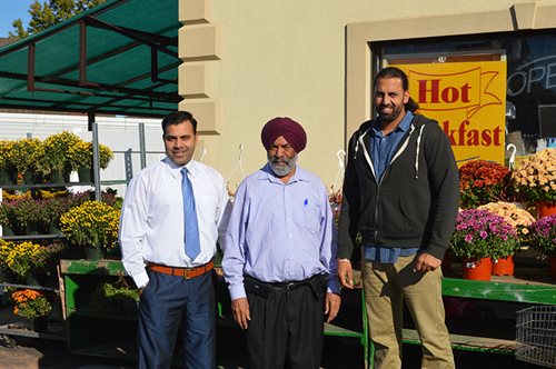 Mr. Singh and his sons in front of Sam's Market